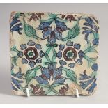 AN 18TH CENTURY NORTH AFRICAN TUNISIAN GLAZED POTTERY TILE, painted with floral motif. 15cm square