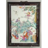 A CHINESE FAMILLE ROSE PORCELAIN PANEL encased within in a hardwood frame, the panel painted with