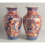 A LARGE PAIR OF JAPANESE IMARI VASES, each with ribbed body and painted with foliate decoration,