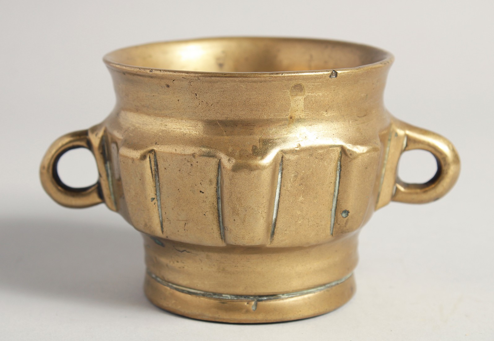 A 14TH/15TH CENTURY HISPANO MORESQUE BRASS MORTAR, with twin handles, 15cm wide (handle to handle).