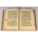 A LARGE NORTH AFRICAN LEATHER-BOUND QURAN, 39cm x 30cm.