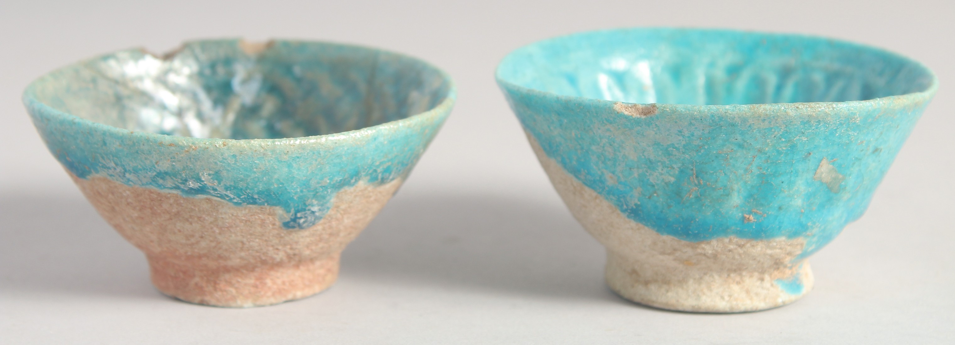 A PAIR OF TWELFTH CENTURY IRAN KASHAN GLAZED TURQUOISE POTTERY BOWLS. Both 8.5cm diameter