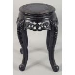 A SMALL CHINESE EBONISED CARVED HARDWOOD STAND, with carved and pierced frieze supported on four