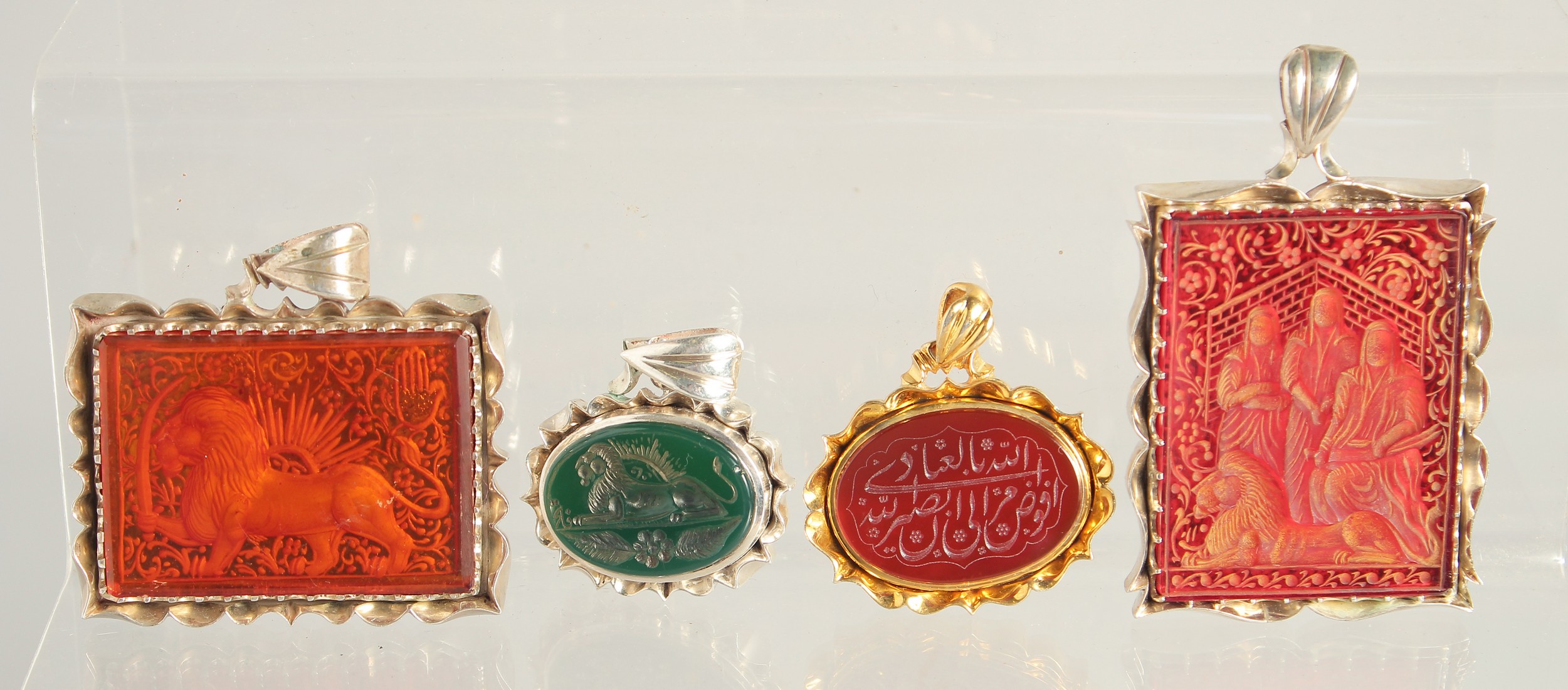 FOUR ISLAMIC PENDANTS; INCLUDING TWO SEALS, carved in various stones, (4).