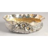 A TURKISH SILVER OVAL SHAPED BOWL, with moulded rim, repousse decoration and applied flower heads,