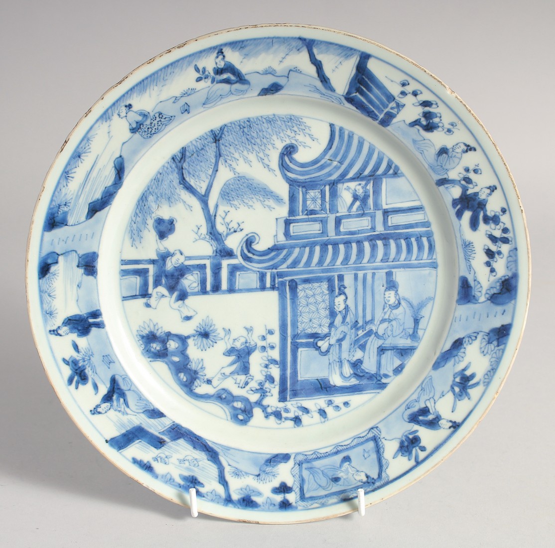 A CHINESE BLUE AND WHITE PORCELAIN PLATE, painted with figures in a courtyard, 26cm diameter.