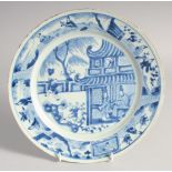 A CHINESE BLUE AND WHITE PORCELAIN PLATE, painted with figures in a courtyard, 26cm diameter.