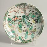 A CHINESE FAMILLE VERTE PORCELAIN DISH painted with various female figures in a garden, with six-