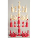 A COLLECTION OF CARVED AND STAINED BONE CHESS PIECES.