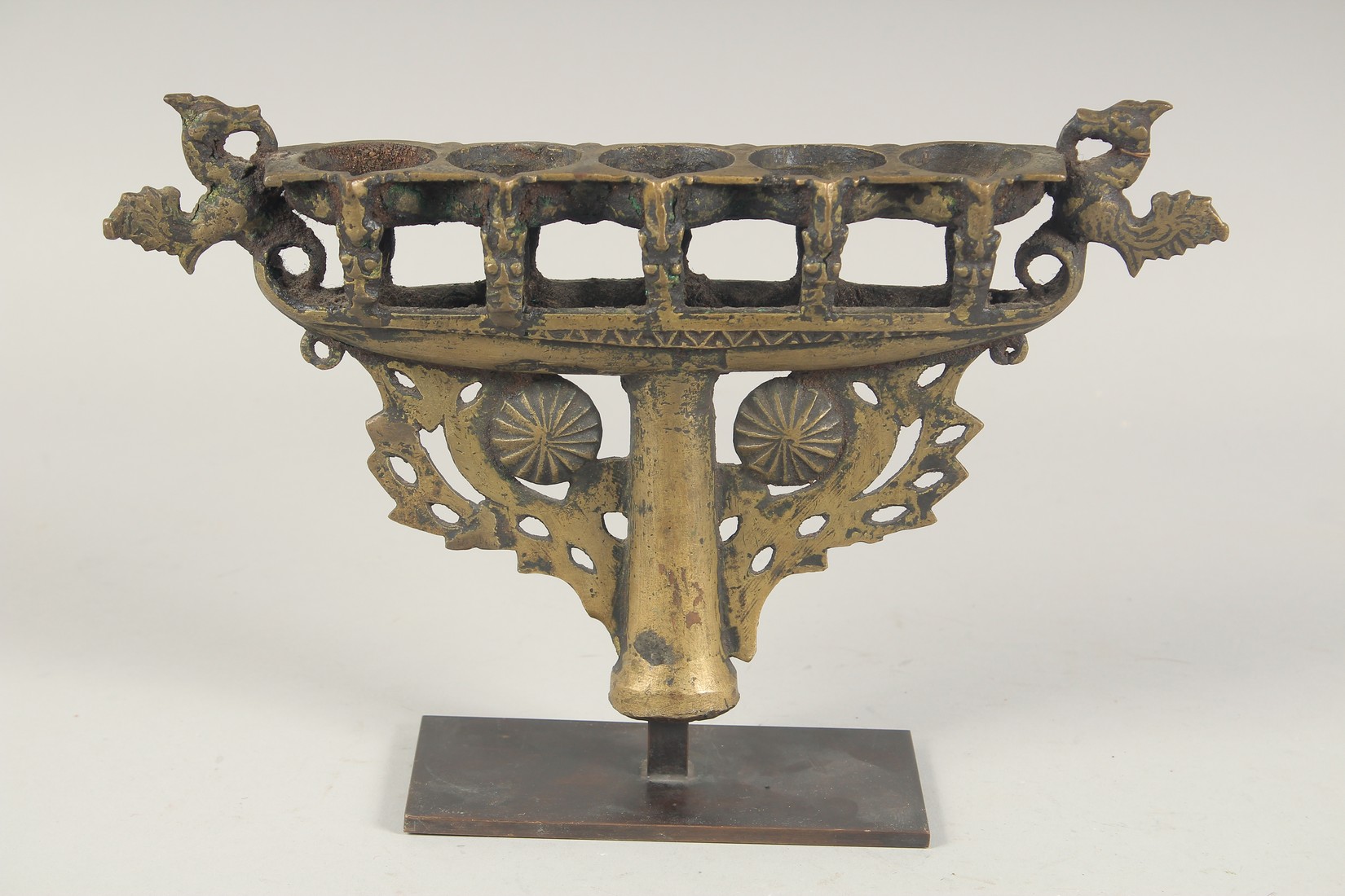 AN ISLAMIC CAST BRONZE FIVE BURNER CANDLESTICK, mounted to a later stand, 31cm wide. - Image 2 of 2