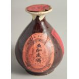 A CHINESE GLAZED POTTERY LIQUOR BOTTLE, (complete; containing liquid).