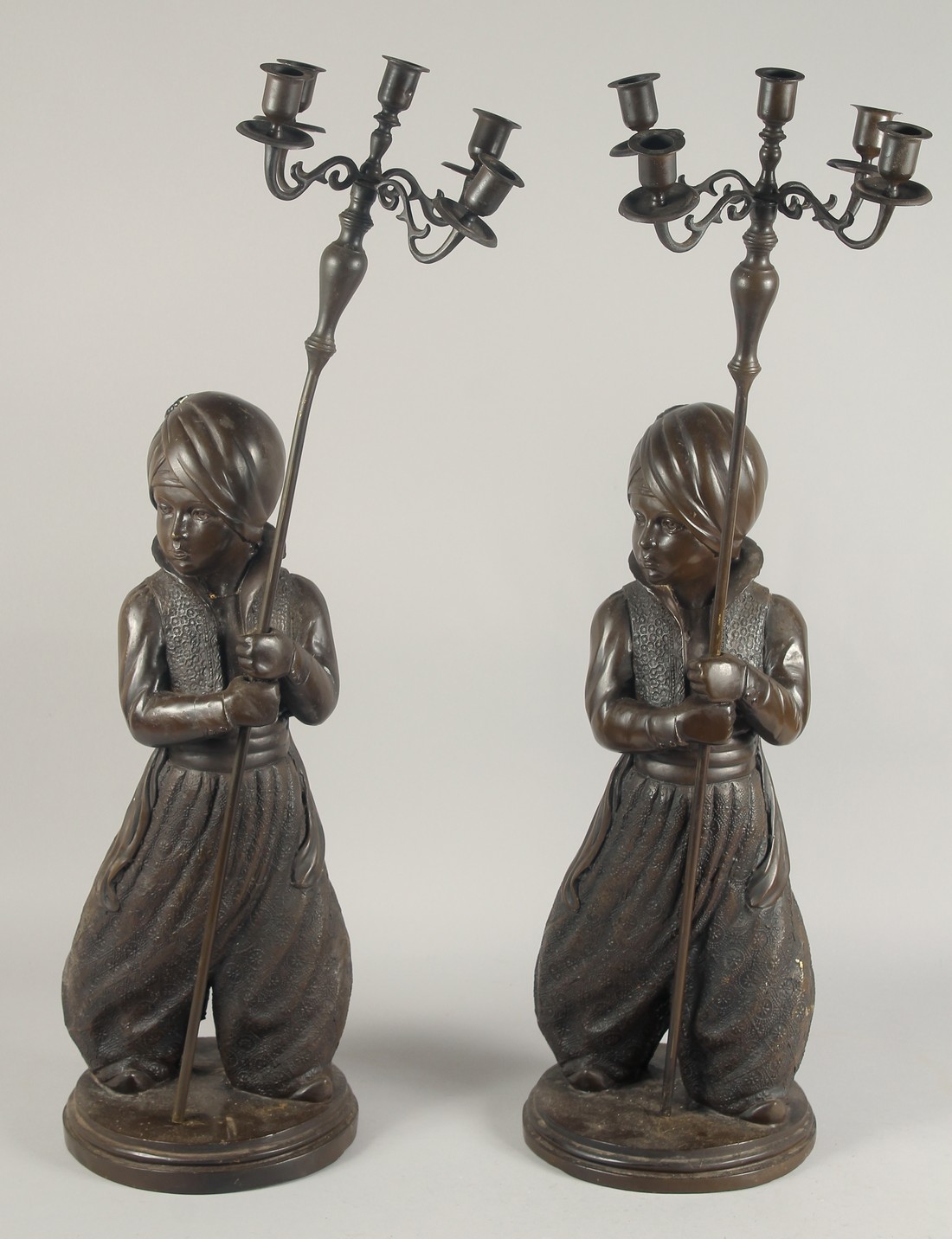 A LARGE PAIR OF FIGURAL BRONZE CANDELABRA, each with a standing Nubian figure holding a staff with