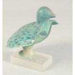 AN EARLY KASHAN TURQUOISE GLAZED POTTERY BIRD ON MOUNT, 14cm long.