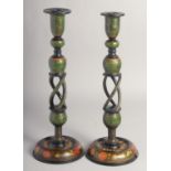 A PAIR OF EARLY 20TH CENTURY INDIAN KASHMIRI LACQUERED CANDLESTICKS, painted with flora. 37.5cm