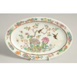 A SMALL CHINESE FAMILLE ROSE PORCELAIN OVAL DISH, painted with birds and native flora, six-character