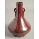 A CHINESE MOTTLED OX BLOOD GLAZE TWIN HANDLE VASE, with impressed mark to base, 22cm high.