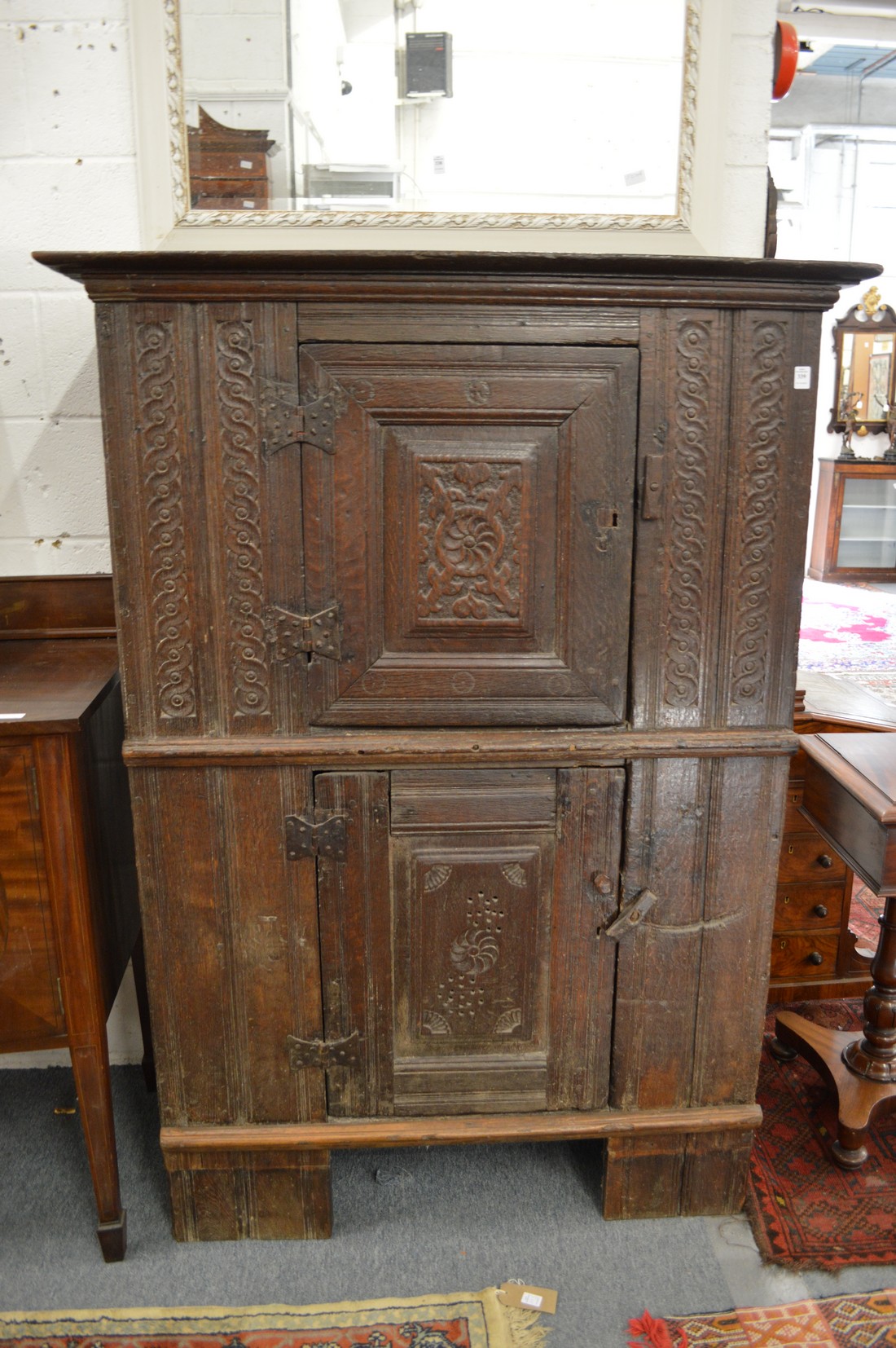 A 17th century and later carved oak livery cupboard with two panelled doors.