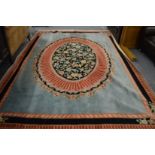 A large French design carpet, turquoise ground with central oval background panel decorated with