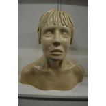 An unusual cream pottery bust of a youth.