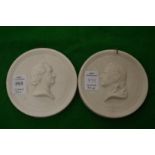 A pair of circular bisque porcelain portrait plaques.