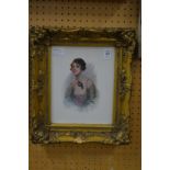 A bust length portrait of a young lady holding a mask colour print in a decorative gilt frame.