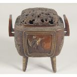 A JAPANESE BRONZE TWIN HANDLE KORO, with foliate openwork lid and raised on four legs, the koro with