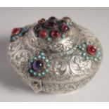 A SMALL TURKISH EMBOSSED AND CHASED SILVER BOX, the hinged lid inset with different beads