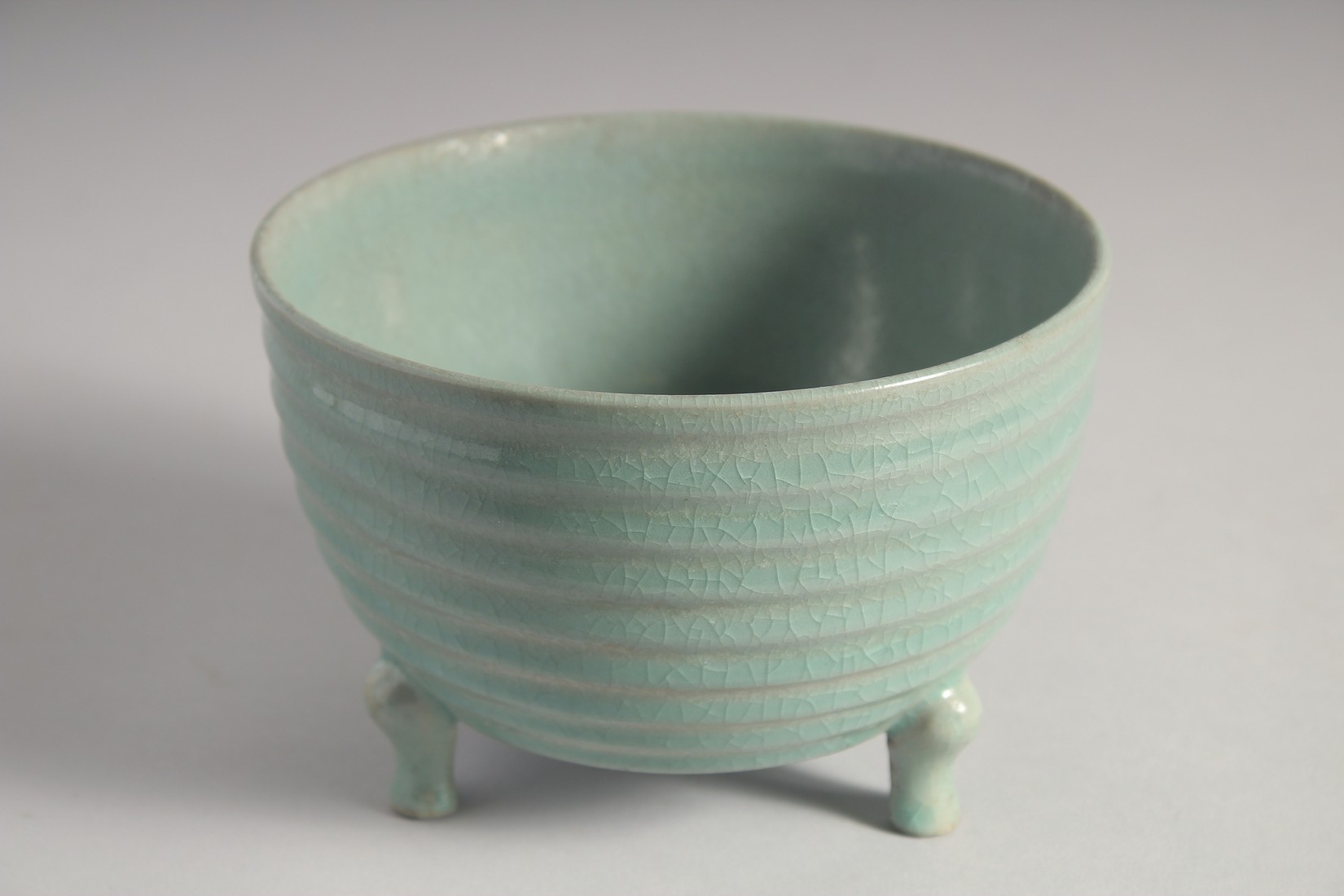 A CHINESE CELADON PORCELAIN TRIPOD CENSER with bronze stand, the base with carved characters. 15.5cm - Image 3 of 9