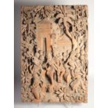 A FINE INDONESIAN CARVED WOOD PANEL, carved with figures and trees with an inscribed temple entrance