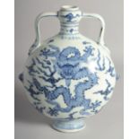 A CHINESE BLUE AND WHITE PORCELAIN TWIN HANDLED MOON FLASK painted with central dragon surrounded by