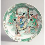 A CHINESE FAMILLE VERTE PORCELAIN PLATE, painted with a female figures playing musical instruments