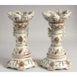 A PAIR OF CHINESE UNDERGLAZE RED AND WHITE PORCELAIN CANDLESTICKS, painted with characters, lotus,