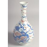 A CHINESE BLUE AND UNDERGLAZE RED PORCELAIN BOTTLE VASE, painted with foo dogs, 23.5cm high.