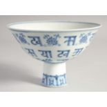 A CHINESE BLUE AND WHITE PORCELAIN STEM CUP painted with lotus and characters, the interior centre