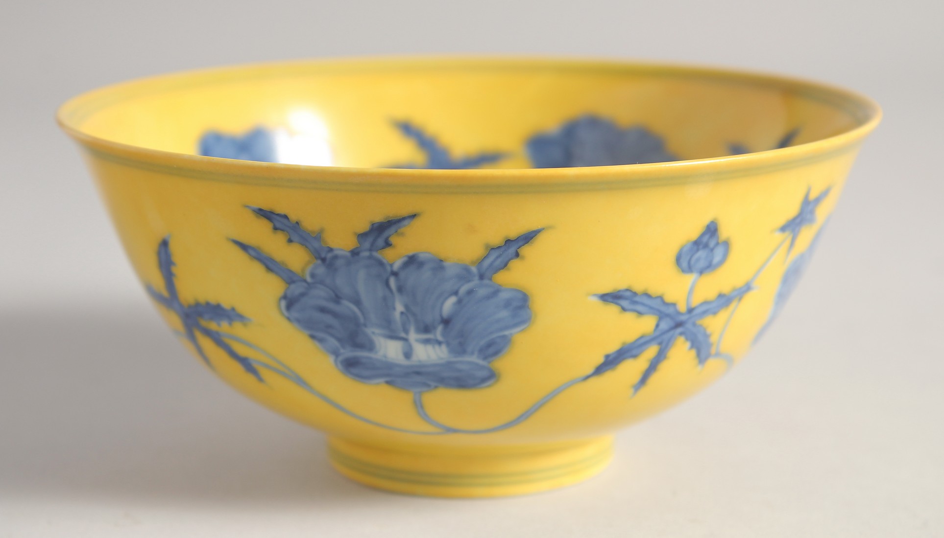 A CHINESE IMPERIAL YELLOW GROUND BLUE AND WHITE PORCELAIN BOWL painted with flower heads, the base