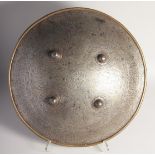 A LARGE PERSIAN QAJAR STEEL SHIELD, with calligraphic panels and four raised bosses, 48cm diameter.