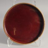 A RED AND GILT LACQUERED WOOD CIRCULAR DISH, with inscription, 22cm diameter.