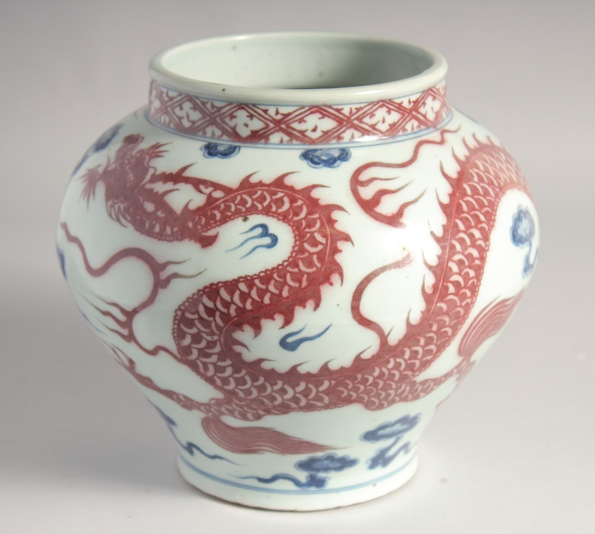 A CHINESE BLUE AND UNDERGLAZE RED PORCELAIN DRAGON JAR, 22cm high.