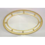 A REGENCY DESIGN OVAL GILTWOOD WALL MIRROR with leaf carved border, ribbon and reed inner frame