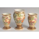 A GARNITURE OF THREE WEDGWOOD VASES painted with panels of fruit. 7.5ins x 6ins high, mark: