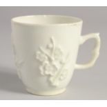 A BOW WHITE GLAZE COFFEE CUP with applied prunus decoration, having an elaborate handle.