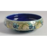 WILLIAM MOORCROFT. GRAPE AND LEAF DESIGN CIRCULAR BOWL with green and blue ground. Impressed: