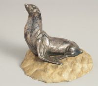 MOREAUX. A MODEL OF A SEA LION on a stone base. Signed. 5ins long.