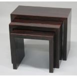 A MODERN NEST OF ROSEWOOD STYLE TABLES. Largest 2ft long x 1ft wide x 1ft 7ins high.