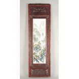 A CHINESE PORCELAIN PANEL, mountain scene with calligraphy in a pierced wooden frame. Panel 29ins