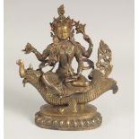 A CHINESE BRONZE GOD FIGURE riding a dragon sat with turquoise and coral. 10ins high.
