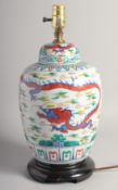 A CHINESE PORCELAIN LAMP decorated with dragons converted to electricity, on a wooden base. 16ins
