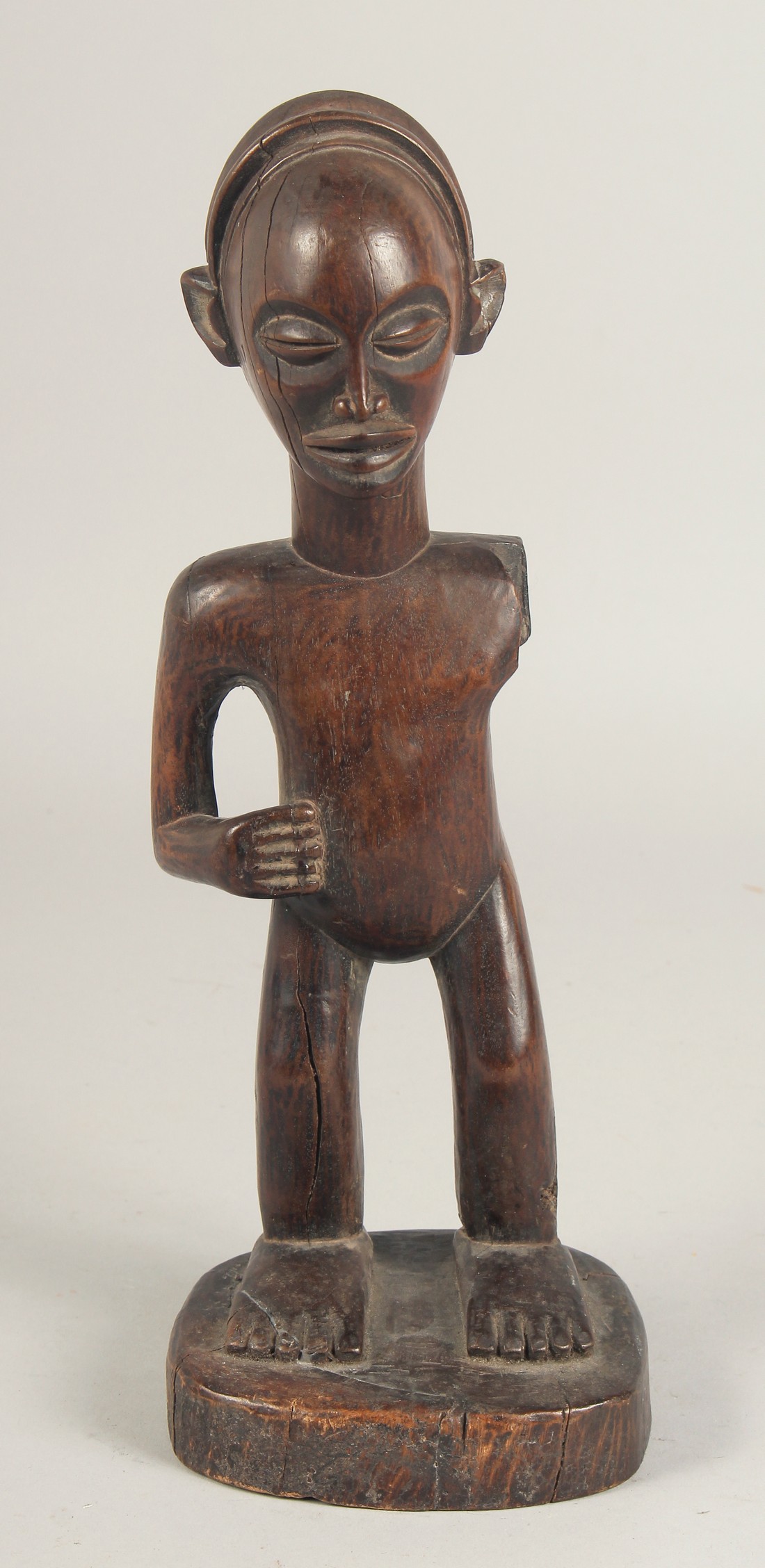 A NATIVE CARVED WOOD STANDING FIGURE, possibly ZULU. (A/F, arm missing). 12.5ins high.