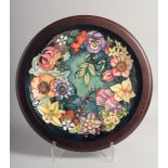 MOORCROFT CAROUSEL DESIGN CIRCULAR CHARGER in an oval frame. Signed Rachel Bishop, no. 208. 12ins