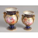 TWO ENGLISH BLUE GROUND URNS painted with a panel of flowers. 5.5ins x 4.5ins high.